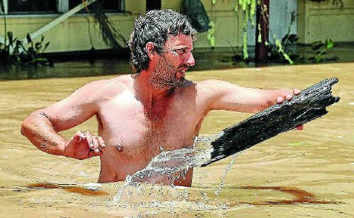 Gary Russell clears debris from his front yard in Rockhampton on January 6. The flood inquiry will hear from Mayor Brad Carter on how the crisis was handled. Gary Russell clears debris from his front yard in Rockhampton on January 6. The flood inquiry will hear from Mayor Brad Carter on how the crisis was handled.